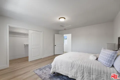 a bedroom with a bed and wooden floor