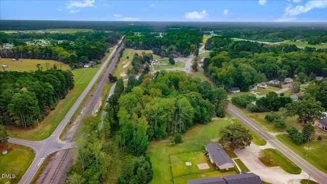 an aerial view of residential houses with outdoor space and trees