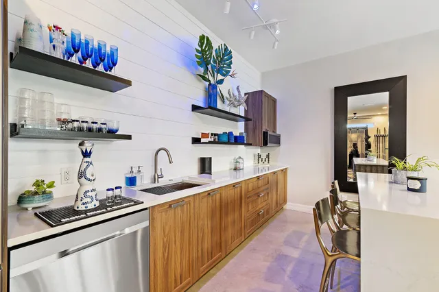 a view of a patio with couches table and chairs under an umbrella