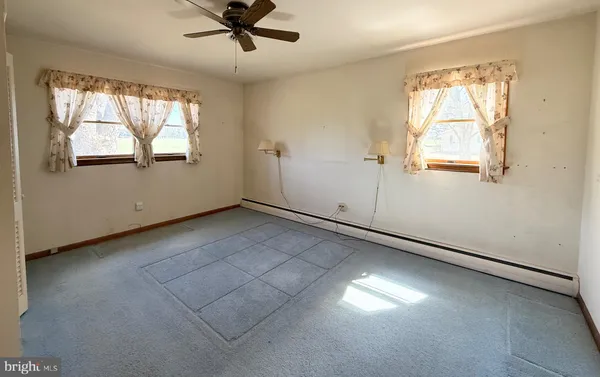 an empty room with windows and closet