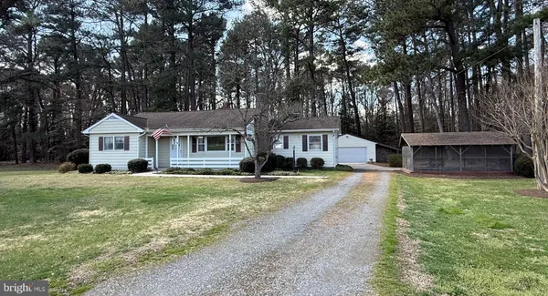 a front view of a house with a yard and trees
