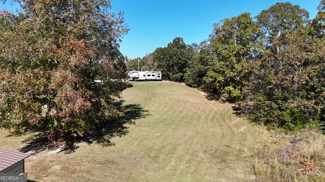 a aerial view of a house with a big yard and large trees