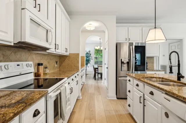 a kitchen with stainless steel appliances granite countertop a sink a stove and a refrigerator