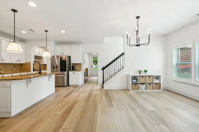 a kitchen with stainless steel appliances a refrigerator and a wooden floor