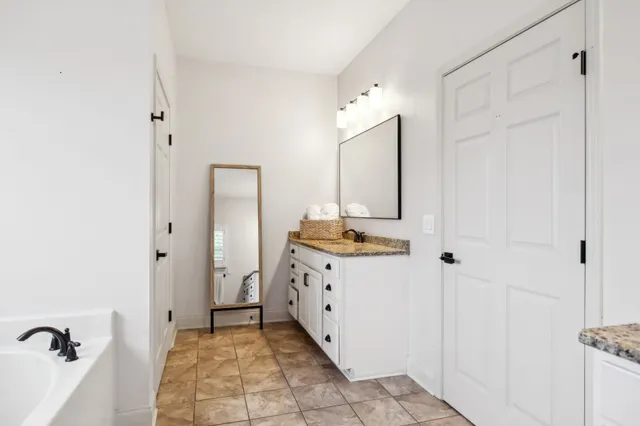 a bathroom with a granite countertop sink and a mirror