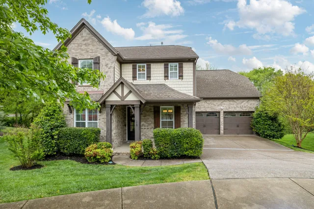 a front view of a house with a garden and plants