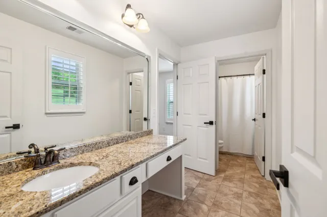 a bathroom with a granite countertop sink and a mirror