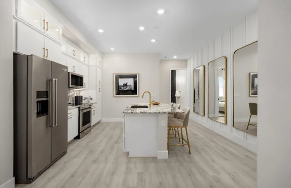 a kitchen with a sink appliances cabinets and furniture