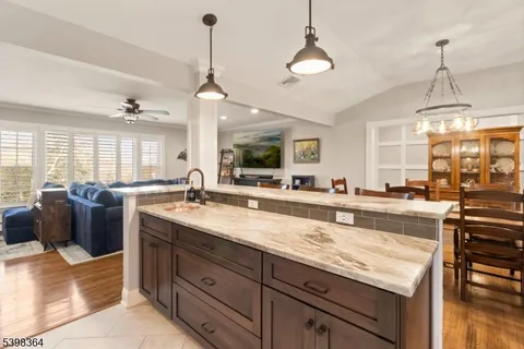 a large kitchen with kitchen island a large counter top a sink and stainless steel appliances
