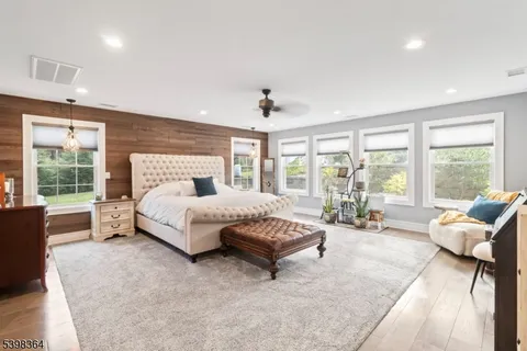 a spacious bedroom with a bed and glass window