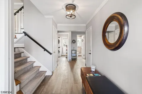 a view of a hallway with wooden floor and staircase