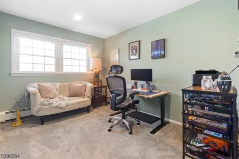 a view of a workspace with furniture and a window