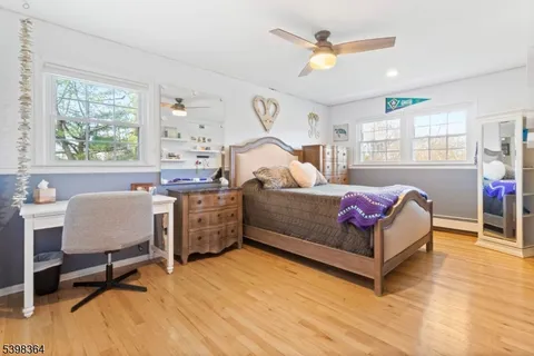 a living room with furniture large window and wooden floor