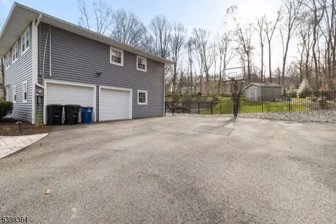a view of a house with a big yard and large trees