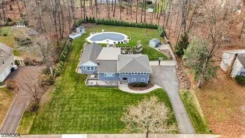 an aerial view of a house with garden space and swimming pool