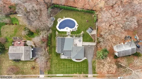 an aerial view of a house with a swimming pool and garden