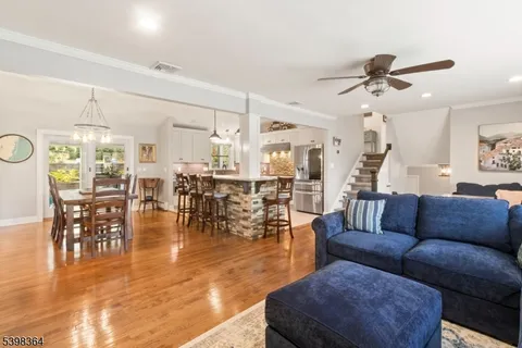 a living room with furniture wooden floor and kitchen view