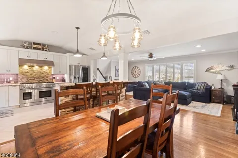 a living room with lots of white furniture and chandelier