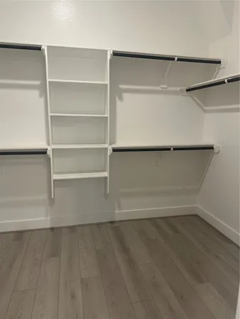 a view of walk in closet with empty racks
