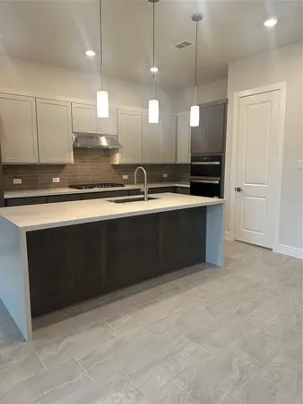 a large kitchen with kitchen island a sink stainless steel appliances and cabinets
