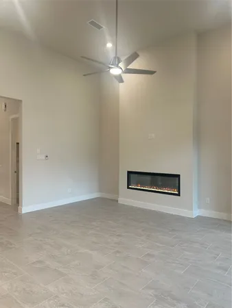 an empty room with a ceiling fan and carpet