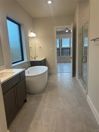 a spacious bathroom with a bathtub shower sink and mirror