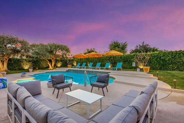 a view of a patio with couches and table and chairs and floor to a yard