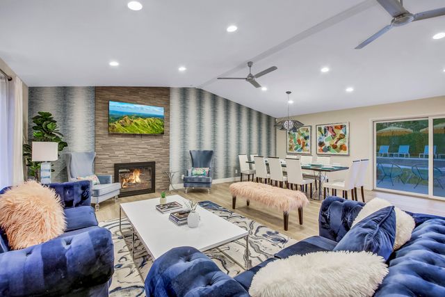 a kitchen with stainless steel appliances granite countertop a stove top oven a sink dishwasher a refrigerator and white cabinets with wooden floor