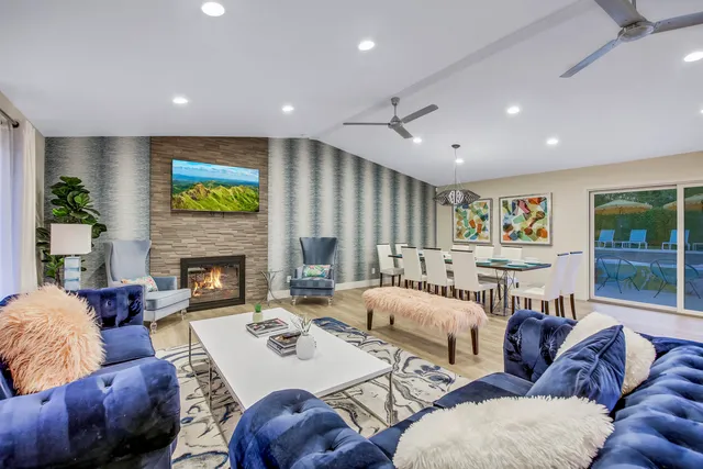 a kitchen with stainless steel appliances granite countertop a stove top oven a sink dishwasher a refrigerator and white cabinets with wooden floor