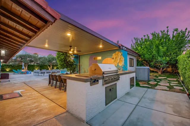 a view of a patio with a table and chairs under an umbrella