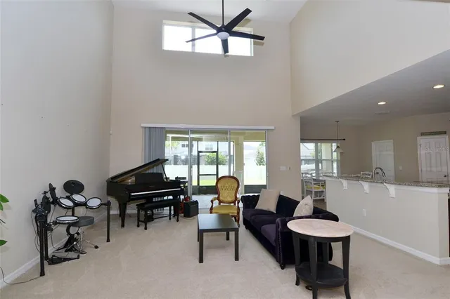 a living room with furniture a piano and a window