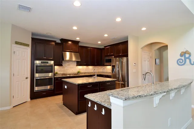 a kitchen with stainless steel appliances granite countertop a sink stove and refrigerator