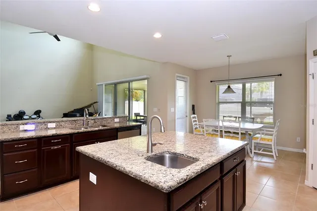 a kitchen with granite countertop kitchen island a sink and a large window