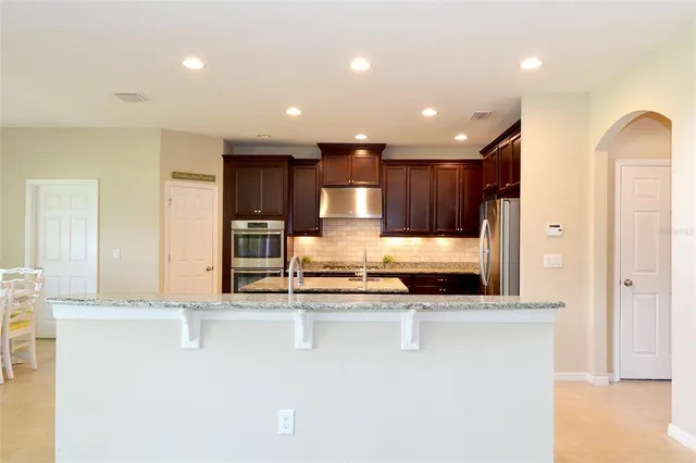 a view of kitchen with kitchen island a sink stainless steel appliances and cabinets