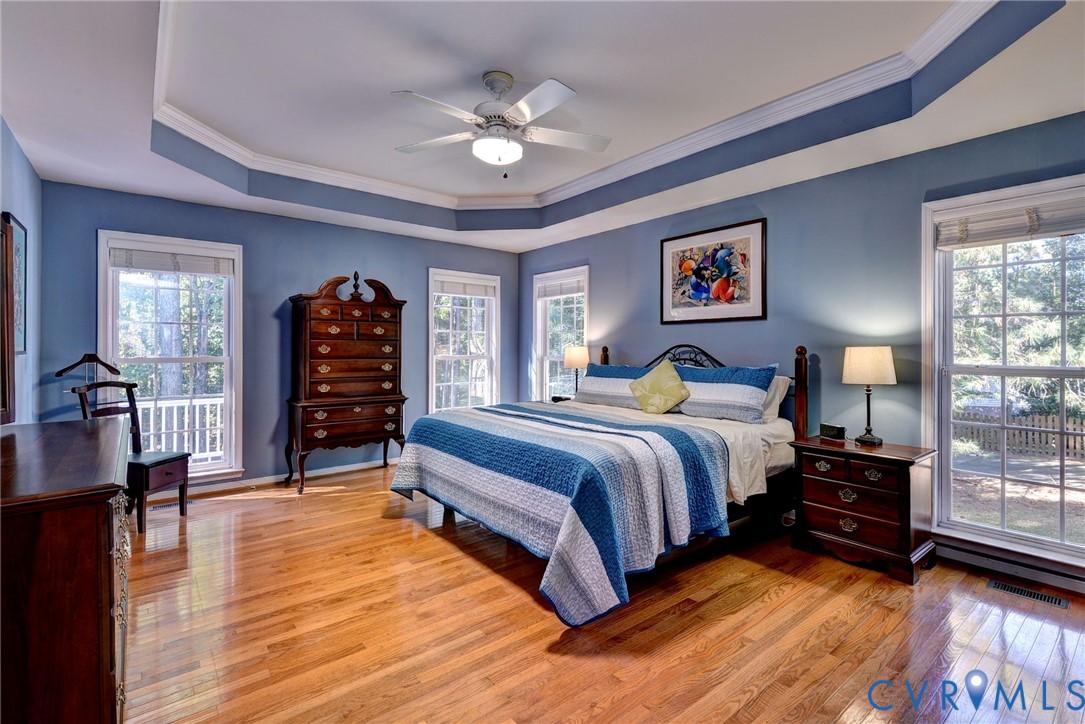 9405 Ashlock Court Toano, VA 23168 - Photo 18 of 43 a spacious bedroom with a large bed a chandelier and windows