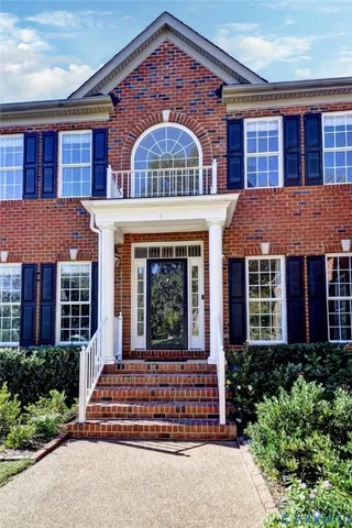 front view of a brick house with a small yard