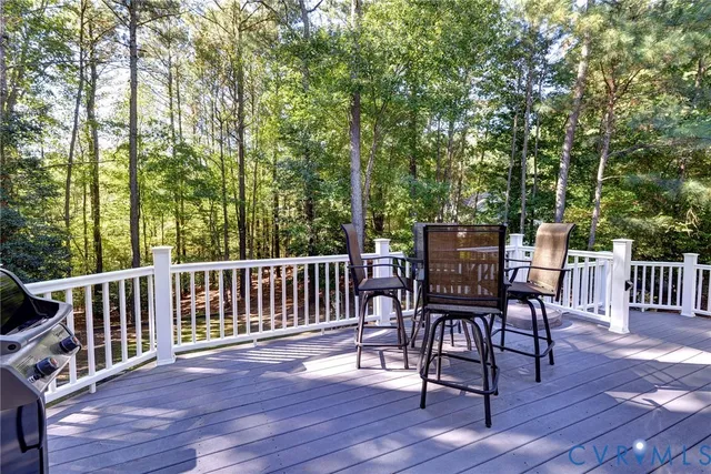 a view of a deck with furniture and trees around