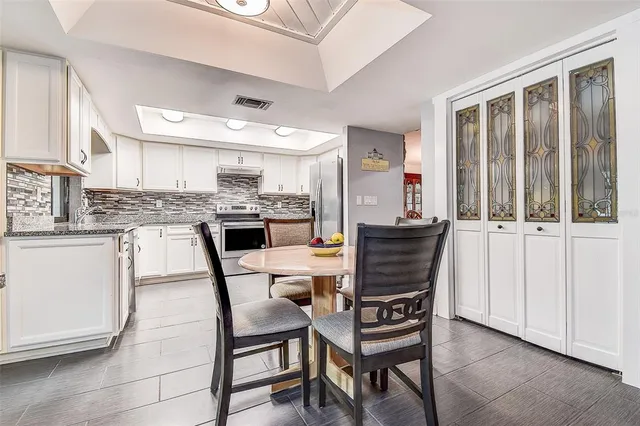 a kitchen with stainless steel appliances granite countertop a sink a stove a refrigerator and cabinets