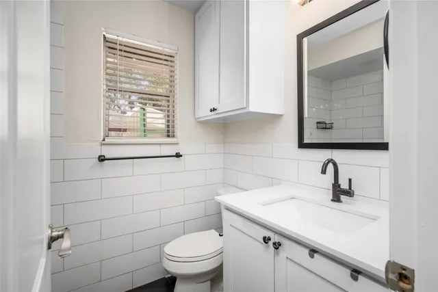 a bathroom with a sink a toilet and a mirror