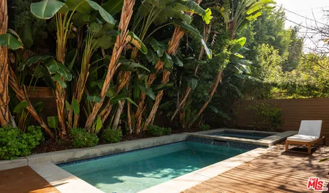 a view of backyard with swimming pool and sitting area