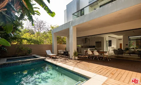 a view of a patio with table and chairs a barbeque with wooden floor and fence