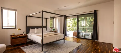 a bedroom with a bed and a flat screen tv