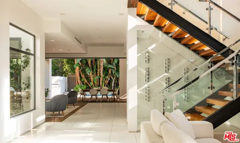 a view of a living room with a floor to ceiling window and stairs