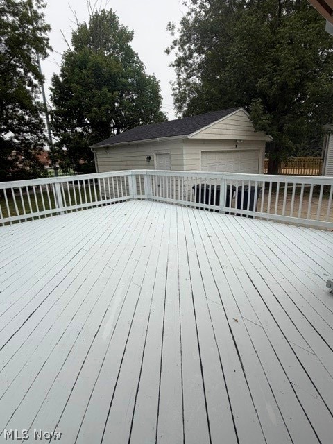 1388 Cranover Road Lyndhurst, OH 44124 - Photo 5 of 35 Spacious white painted deck with wood railings, overlooking a detached garage with a white overhead door and shingled roof