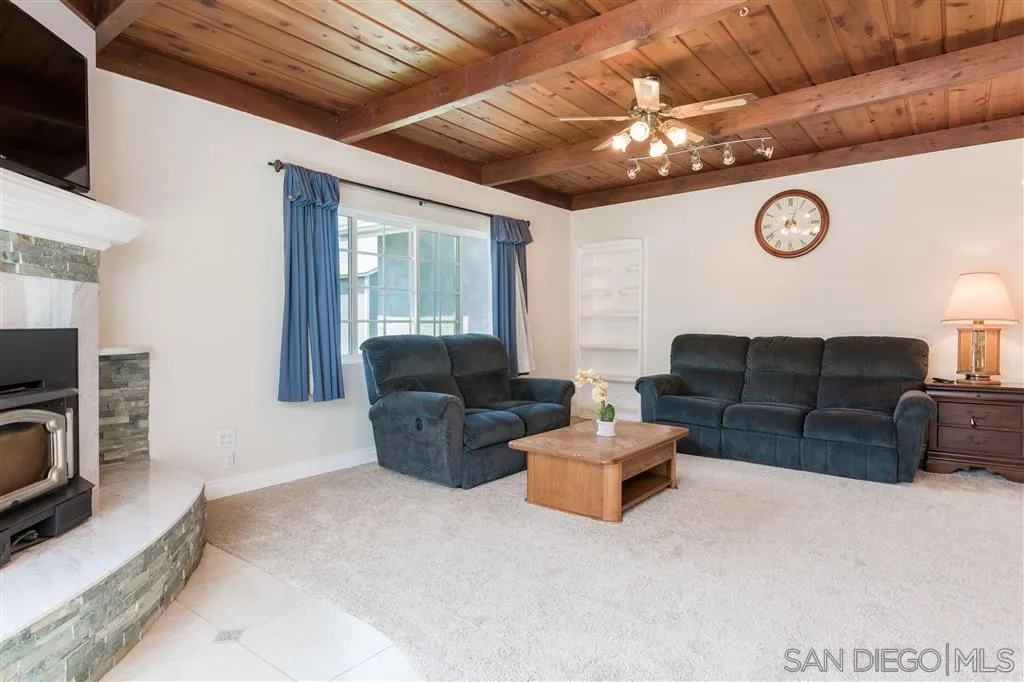 5168 Constitution Road San Diego, CA 92117 - Photo 11 of 25 a living room with furniture a clock and a flat screen tv