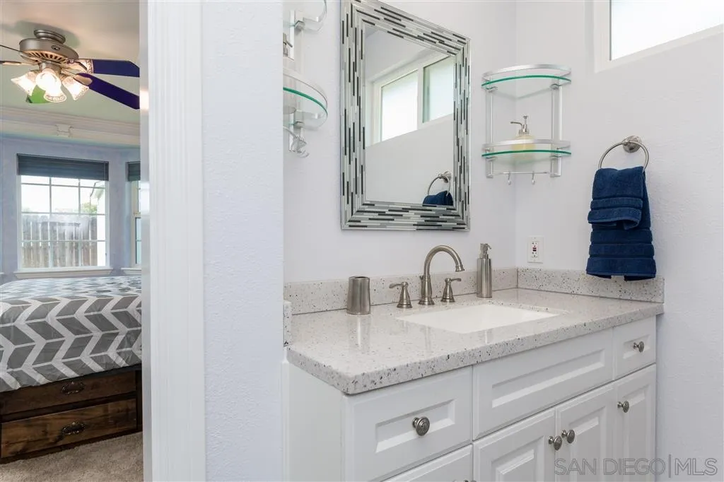 5168 Constitution Road San Diego, CA 92117 - Photo 15 of 25 a bathroom with a granite countertop sink and a mirror