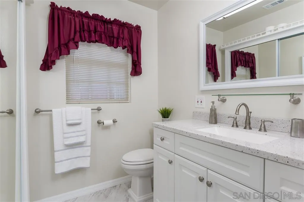 5168 Constitution Road San Diego, CA 92117 - Photo 21 of 25 a bathroom with a toilet sink and mirror