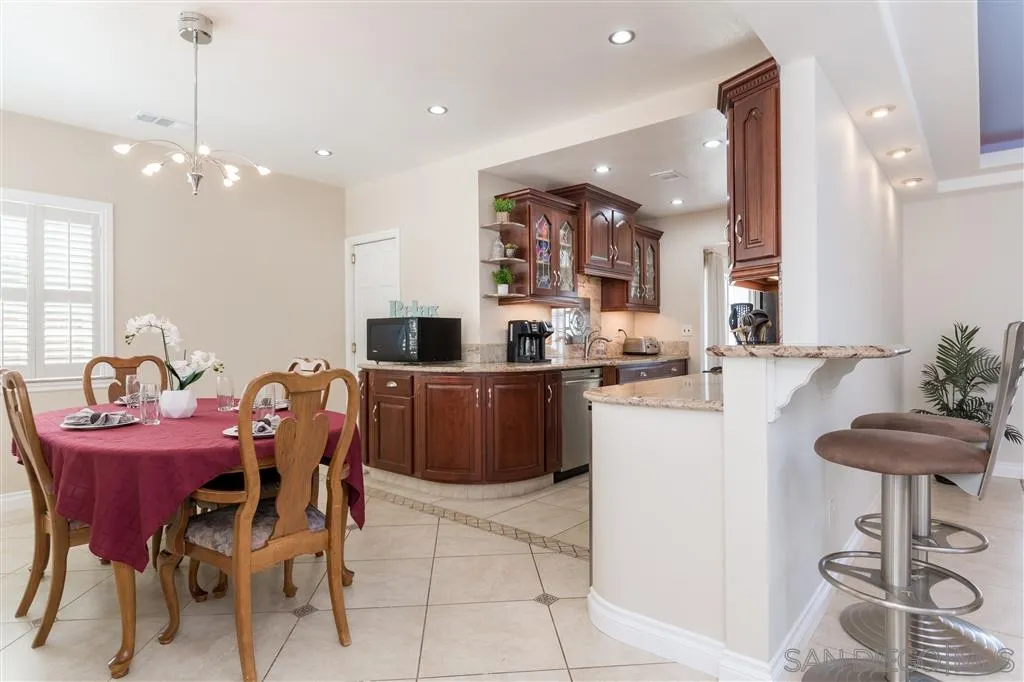 5168 Constitution Road San Diego, CA 92117 - Photo 5 of 25 a kitchen with a dining table chairs stainless steel appliances and cabinets