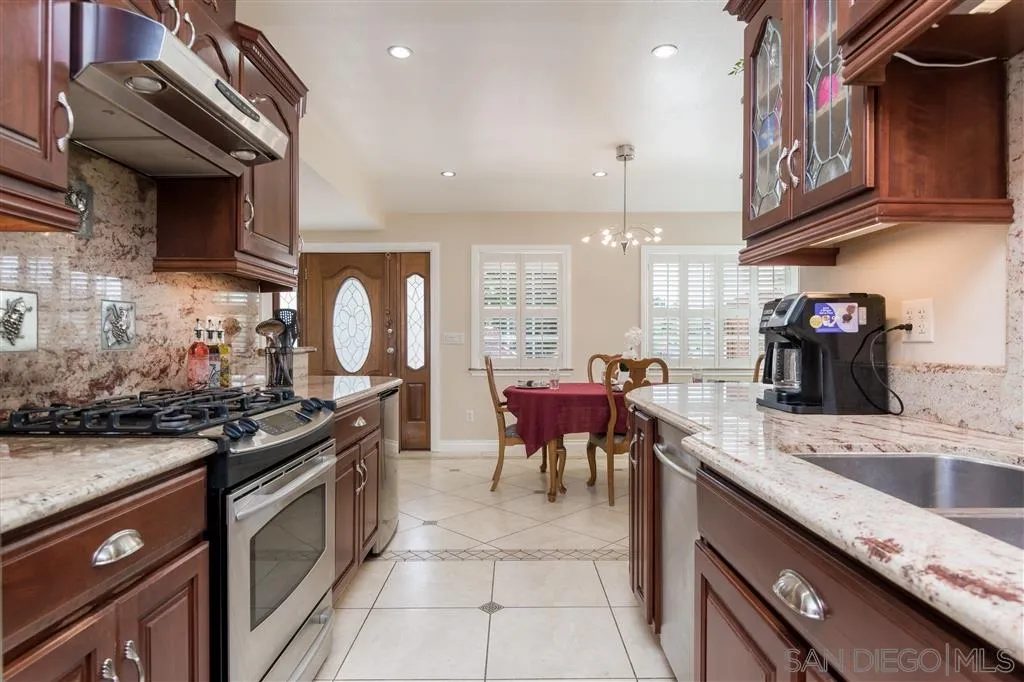 5168 Constitution Road San Diego, CA 92117 - Photo 6 of 25 a kitchen with granite countertop a stove a sink and a refrigerator