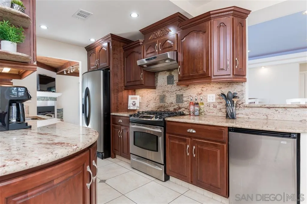 5168 Constitution Road San Diego, CA 92117 - Photo 7 of 25 a kitchen with stainless steel appliances granite countertop a sink stove and refrigerator